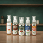 Five Herby spray bottles - Shuddhikaran Herbal Air Purifier, Cockroach Repellent, Super Strong Mosquito Repellent, Lizard Repellent, and Ants & Bed Bugs Repellent - lined up on a wooden table
